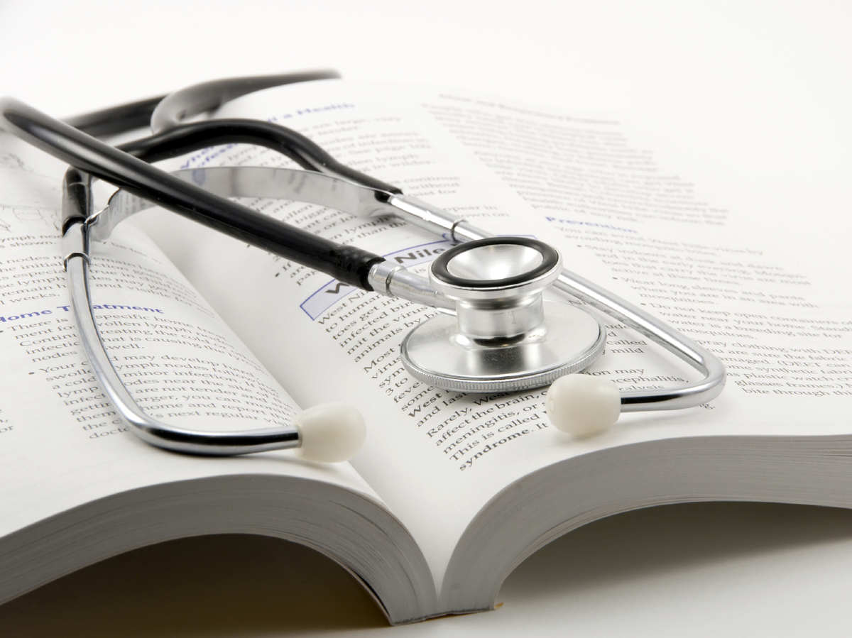 stethoscope on open book on a white background